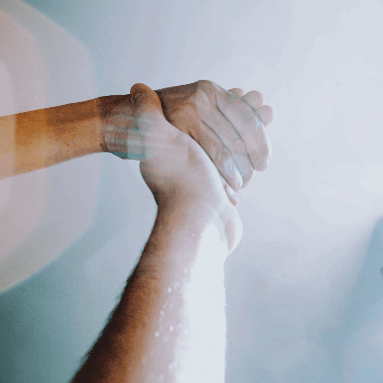 Two hands are shown holding with light reflections, representing the vibrations of the Law of Attraction.