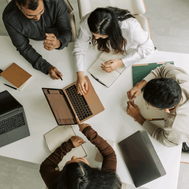 A circle of office workers around a laptop represents using numerology for career advice.