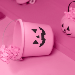 pink jack-o-lantern bucket tipped over spilling pink-covered candy