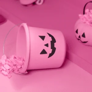 pink jack-o-lantern bucket tipped over spilling pink-covered candy