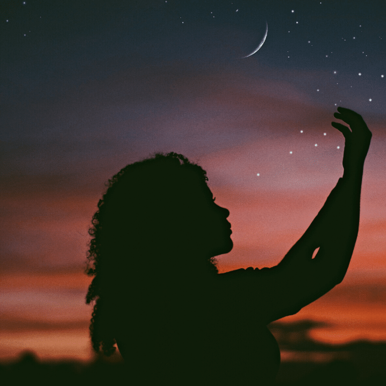 silhouette of a woman reaching her hands up to a pink and purple starry sky with a new moon
