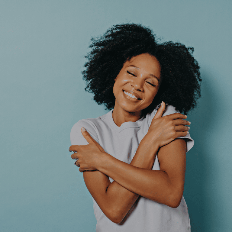 woman smiling and hugging herself