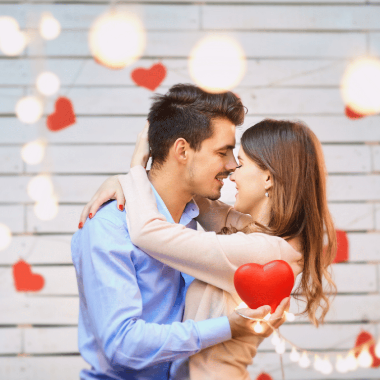 couple staring lovingly at each other surrounded by lights and hearts