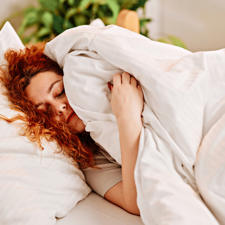 woman with red curly hair sleeping in bed
