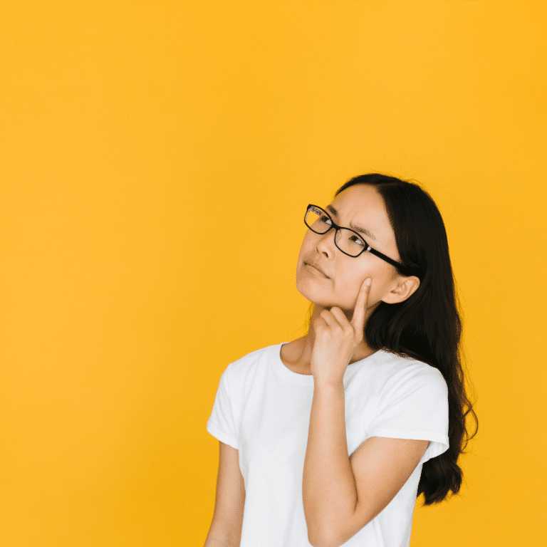 woman with long black hair and glasses staring ahead in question