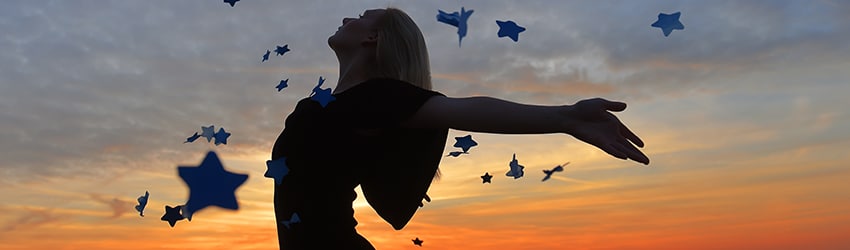 Woman dances under a starry sky.