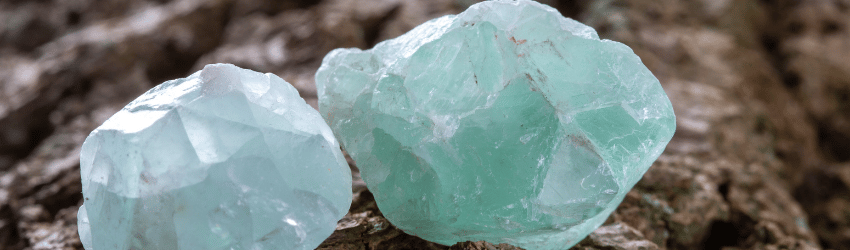 Green aventurine sitting on a rock.