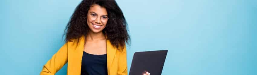 business woman smiling holding a laptop