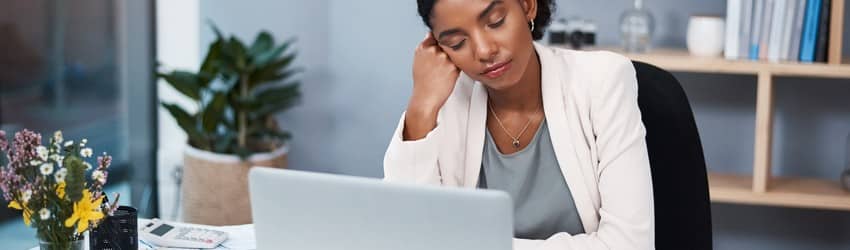 business-woman-sitting-at-desk-looking-very-tired