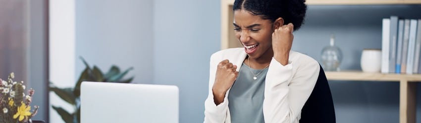 business-woman-sitting-in-her-desk-cheering