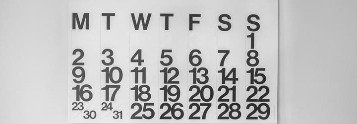 A calendar on a wall showing ever day of the week.