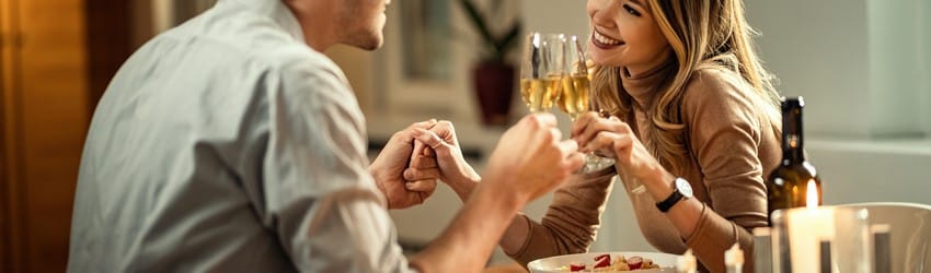 man-and-woman-on-dinner-date-holding-hands-and-drinking-wine