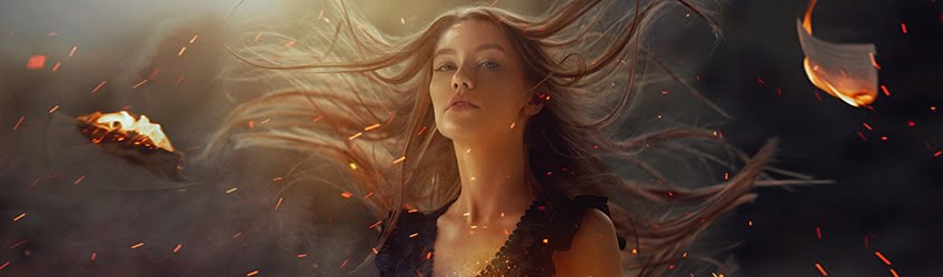 A girl with long flowing hair appears to be standing among embers, sparks, and bits of burning paper.