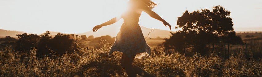 girl-running-in-field-with-sunset
