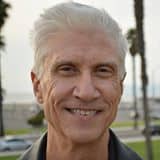 A close-up head shot of Terence Guardino, a smiling man with white hair and friendly eyes.