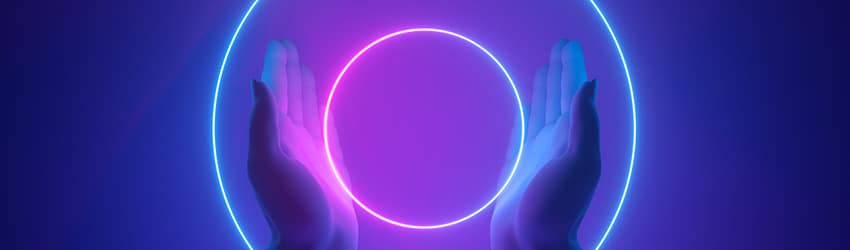 A person holds two rings of neon purple lights between their hands.