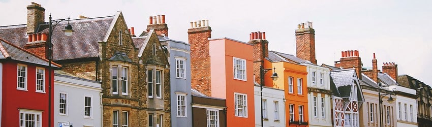 A row of colorful different houses on a block.