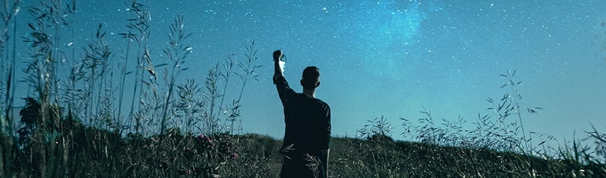 A silhouette of a man on a starry blue background.