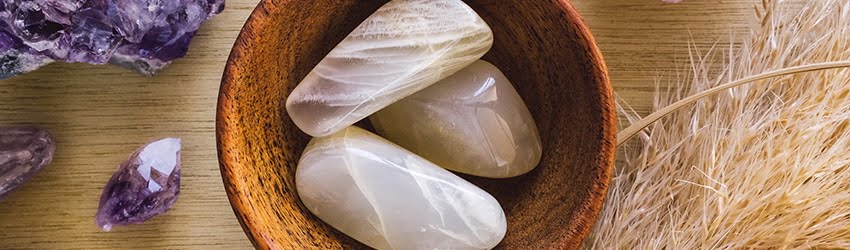 Moonstone in a bowl surrounded by Amethyst crystals.