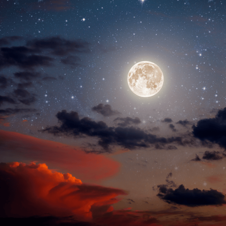 A Full Moon glows in the grey and blue night sky. The stars are visible around it.