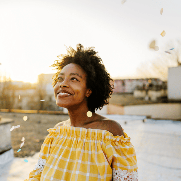 woman smiling up at the sunny sky