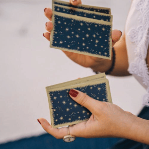 pair of hands shuffling a blue tarot deck