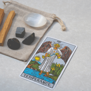 temperance tarot card on a table next to crystals and sage