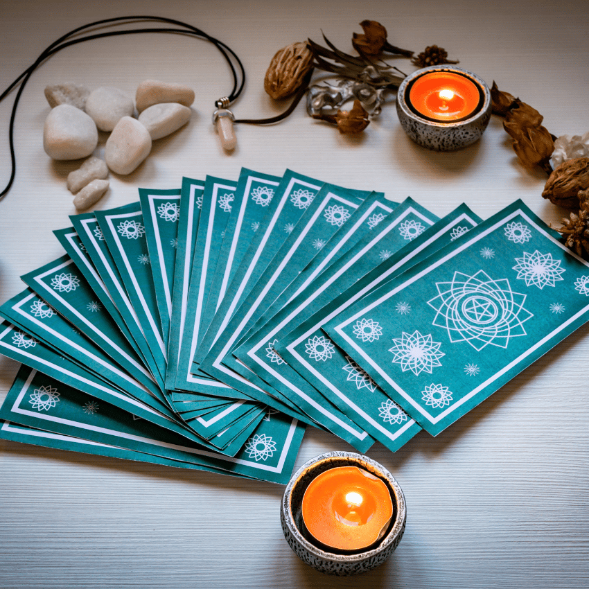 blue tarot cards spread across a white table with crystals and candles