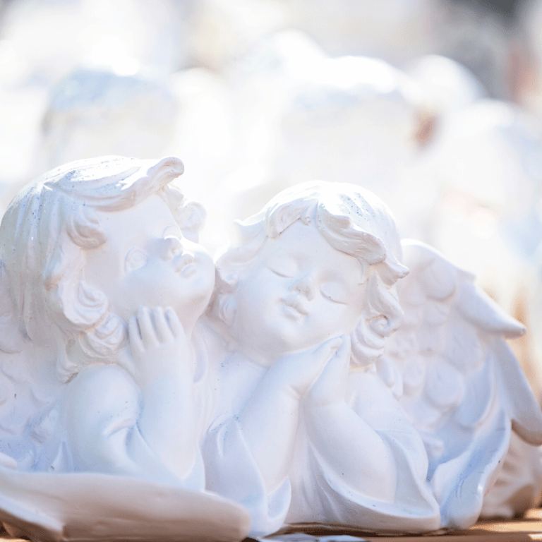 two white ceramic angels gazing ahead