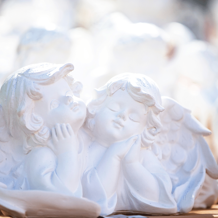 two white ceramic angels gazing ahead