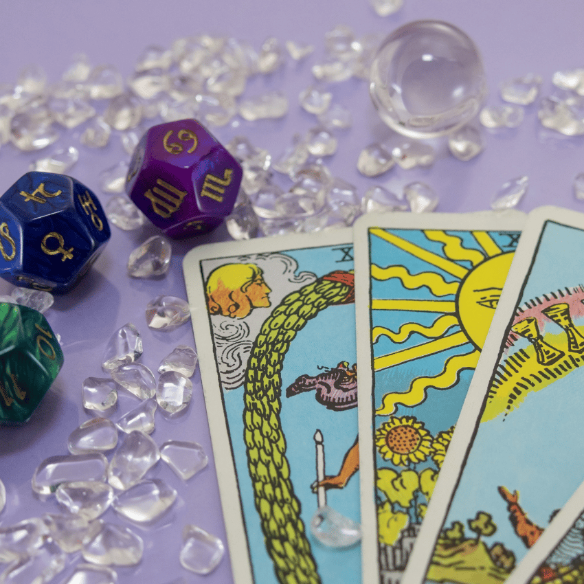 three tarot cards on a purple table covered in white crystals