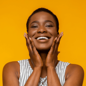 gleeful woman smiling with her hands on her face