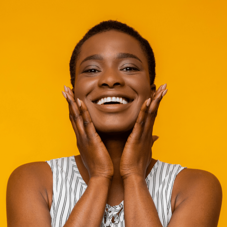 gleeful woman smiling with her hands on her face