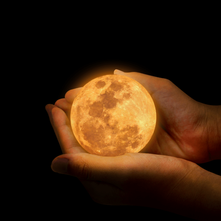 pair of hands holding a small glowing full moon