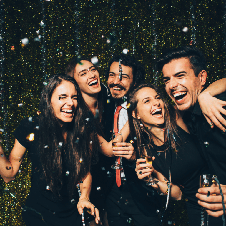 a group of people laughing and celebrating together with confetti and sparklers