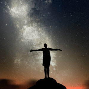 silhouette of a woman standing on a hill with her arms outstretched against a grey starry night
