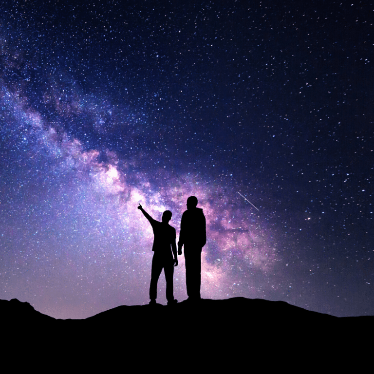 two silhouettes of people gazing at a purple and blue starry sky