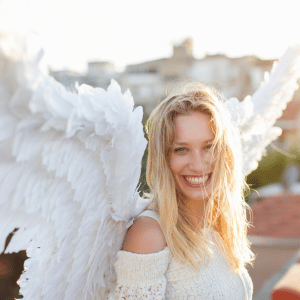 blonde woman with angel wings smiling brightly