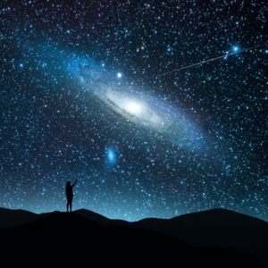 black silhouette of a person standing on rocky ground pointing up at an array of stars in the sky