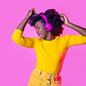 woman in yellow dancing with bright pink headphones on