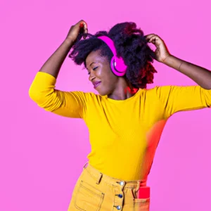 woman in yellow dancing with bright pink headphones on