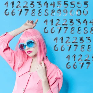 funky woman with pink hair, blue glasses, and a pink shirt standing in front of floating numbers against a blue backdrop