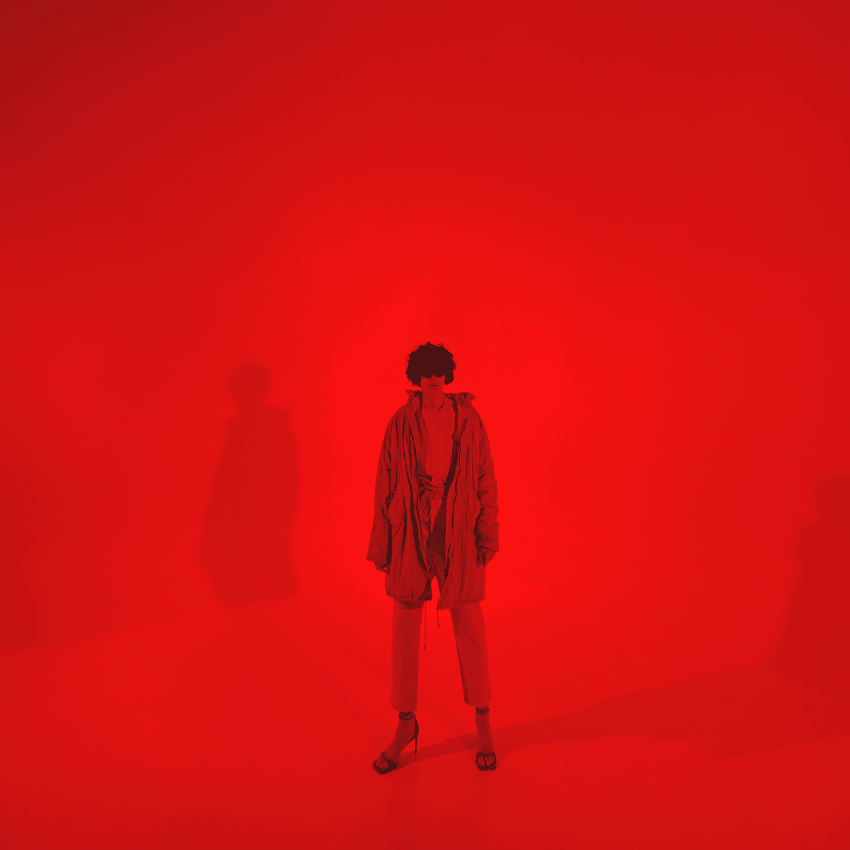 man in all red standing against a red backdrop