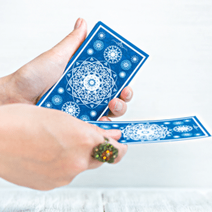 pair of hands shuffling blue tarot cards