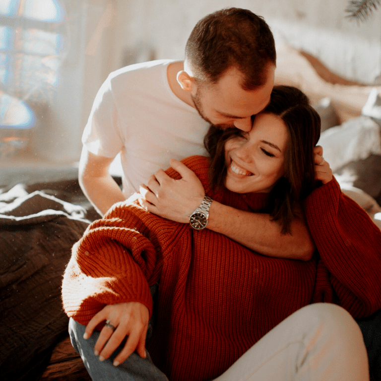 man and woman cuddling and smiling joyfully