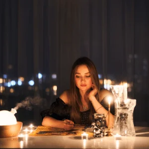 brunette woman sitting at a table gazing down at a pile of cards