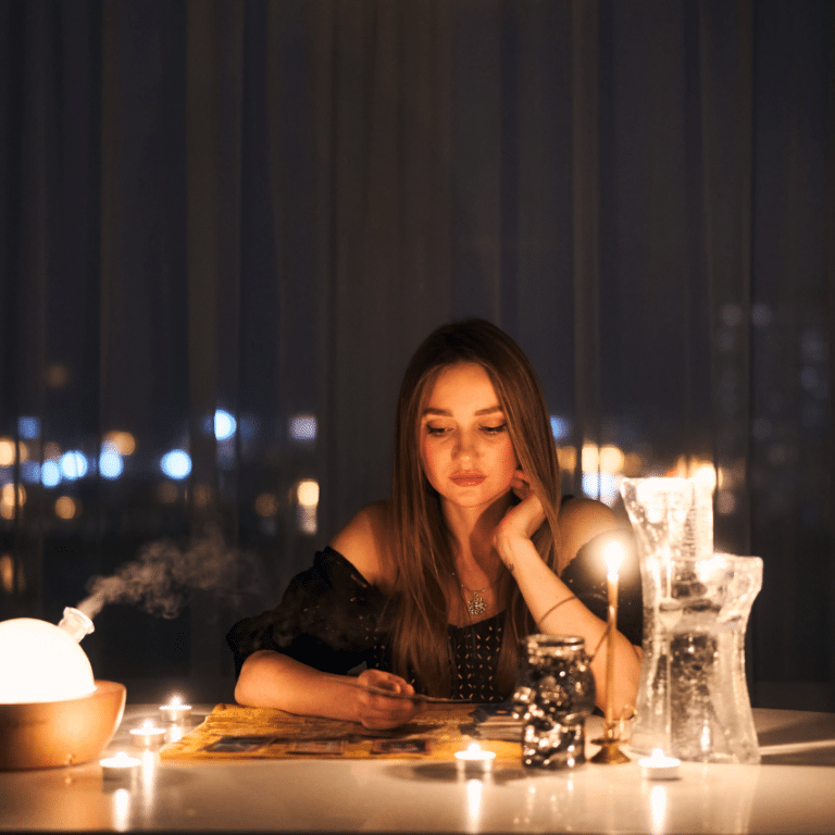 brunette woman sitting at a table gazing down at a pile of cards