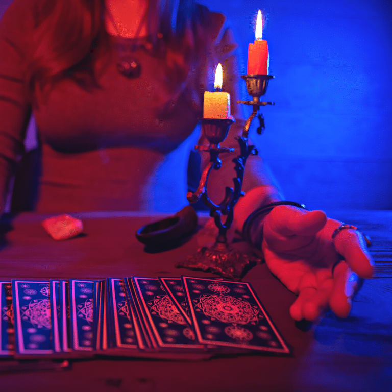 woman in a grey shirt looking over blue tarot cards spread out on a table