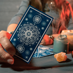 hand holding a blue tarot card forward