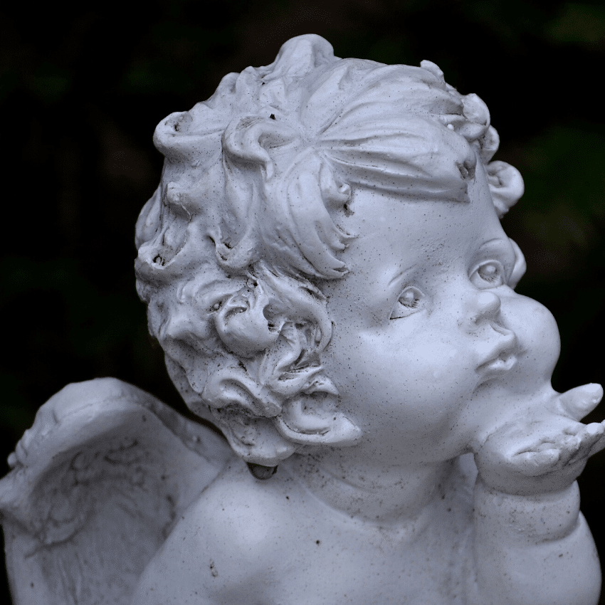 white baby angel statue blowing a kiss